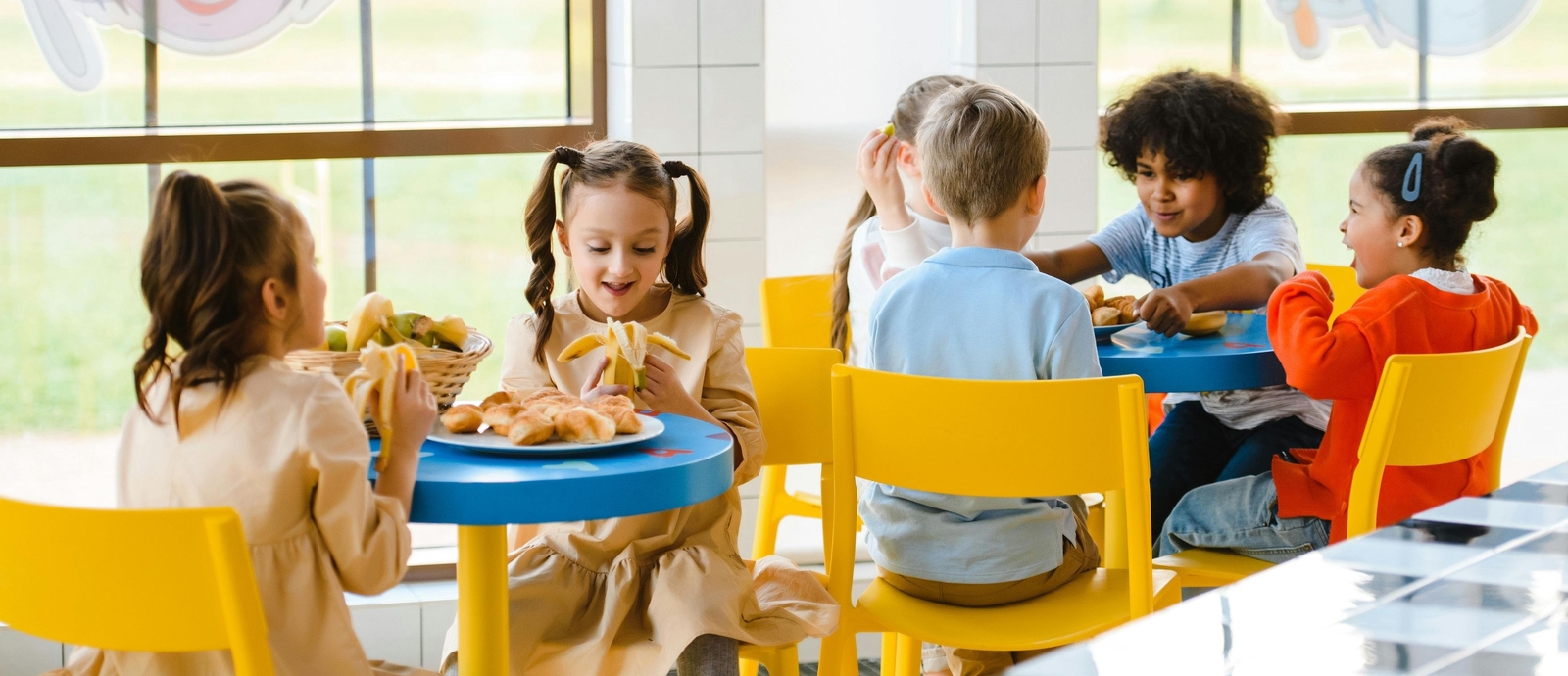 Children eat together at tables